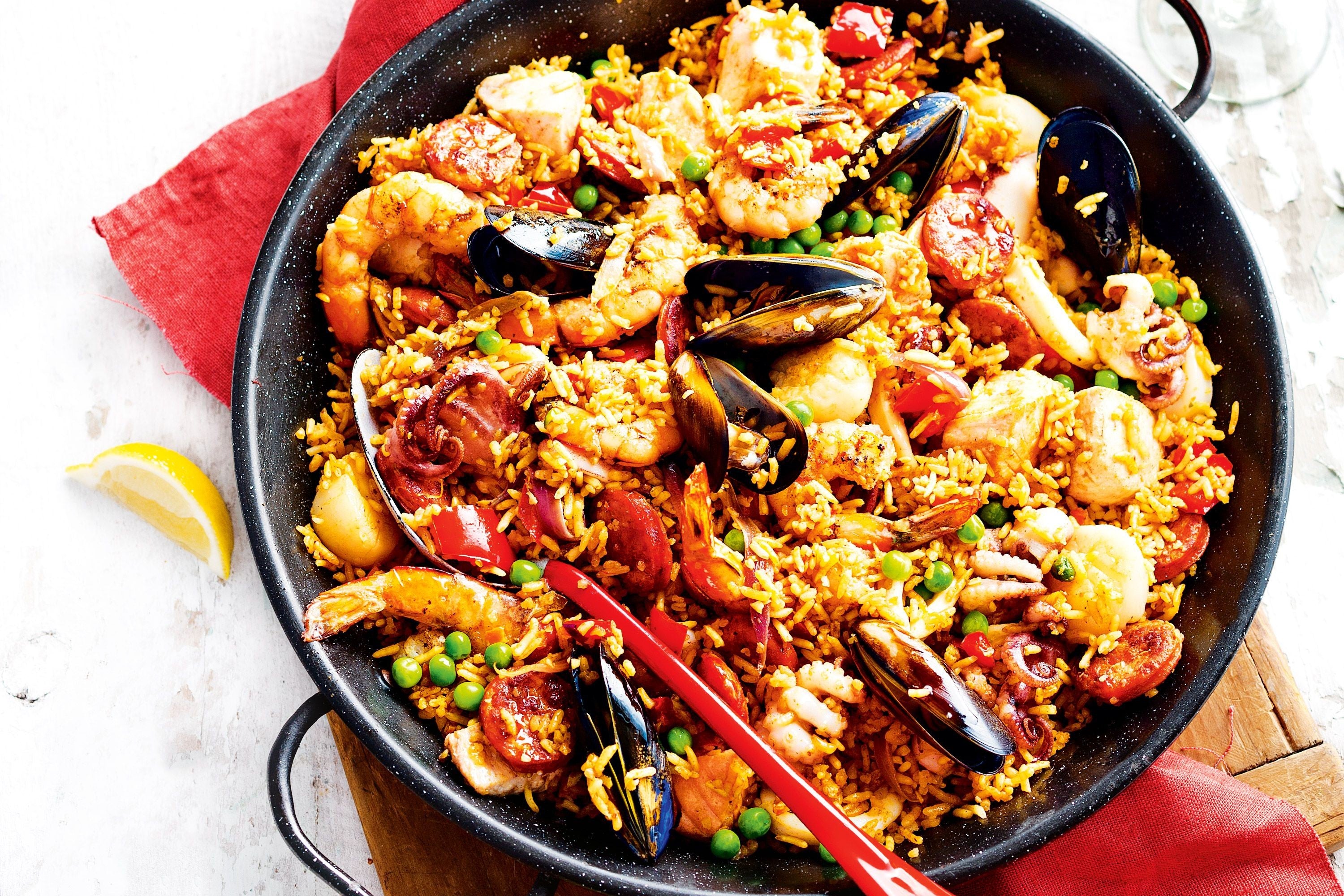 receta detallada para hacer una auténtica paella de mariscos, utilizando mejillones, camarones y calamar, destacando la frescura y calidad